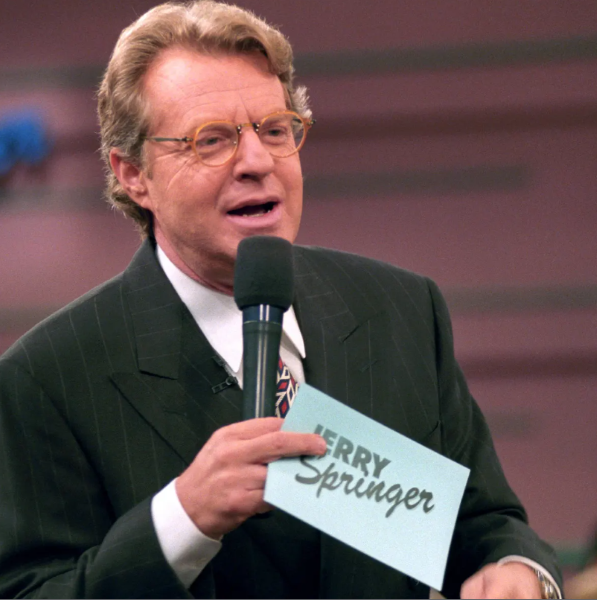 Jerry Springer with a microphone hosting his show